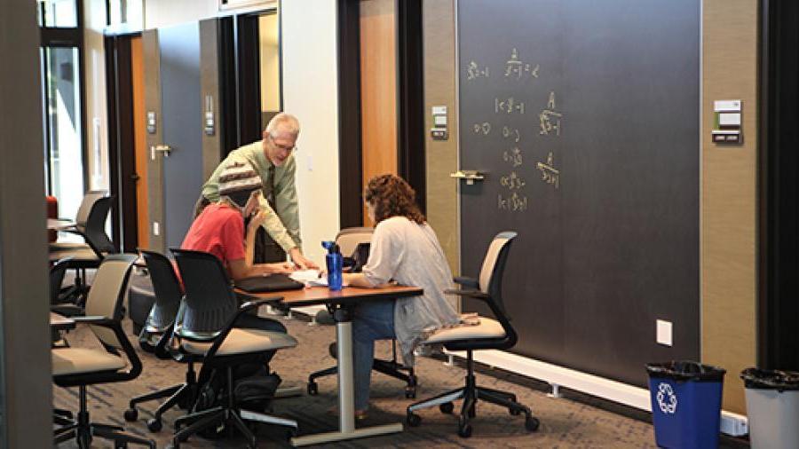 Math professor helping two students in office hours